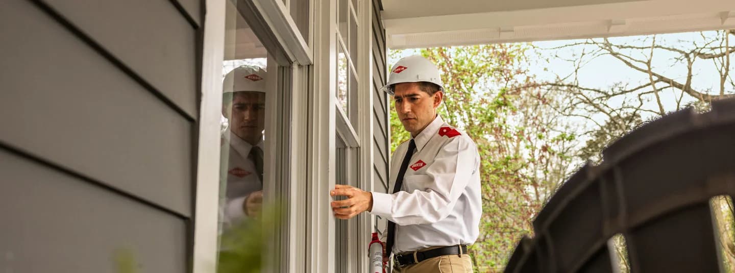 A VectorX specialist sealing the windows outside of a customer's home
